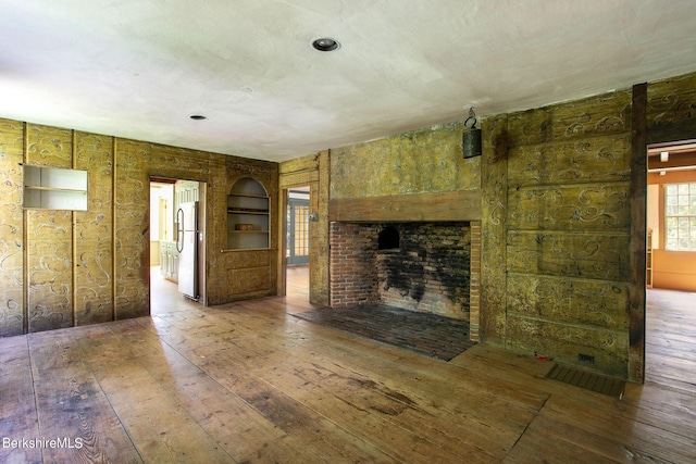 unfurnished living room with hardwood / wood-style flooring and a fireplace