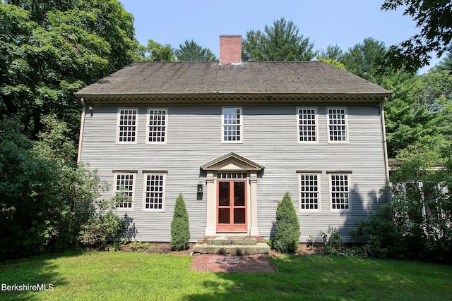 back of house with a lawn