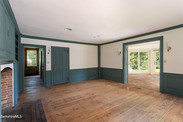 spare room featuring wood-type flooring and ornamental molding