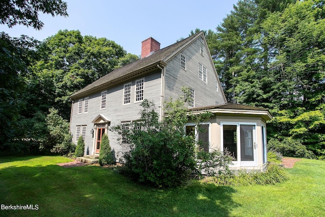 view of side of home with a lawn