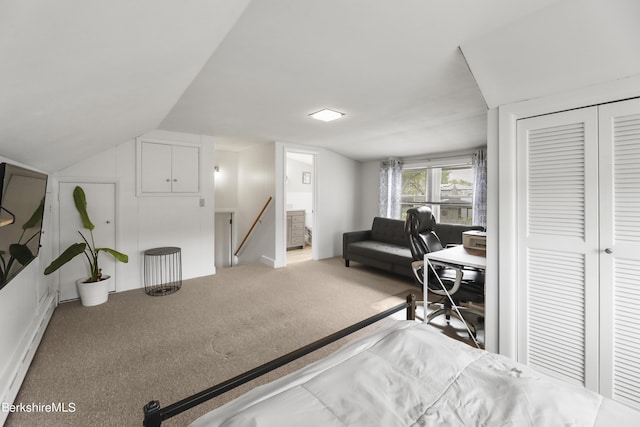 carpeted bedroom featuring lofted ceiling, a closet, and baseboard heating