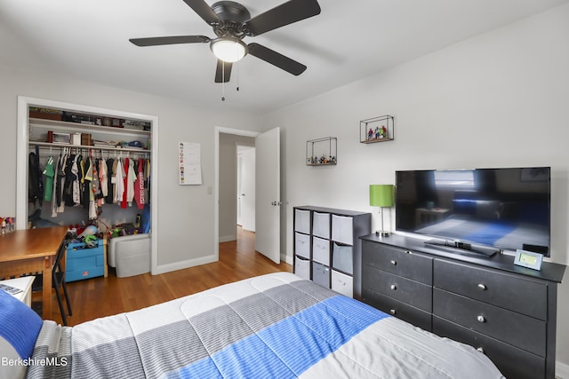 bedroom featuring a closet, baseboards, ceiling fan, and wood finished floors