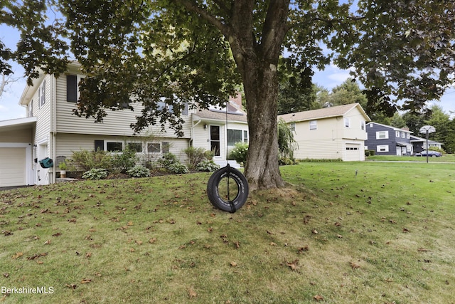 tri-level home with a garage and a front lawn