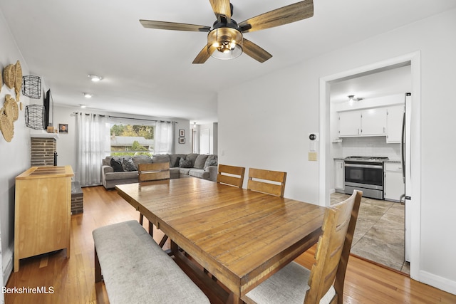 dining room featuring light wood-type flooring and a ceiling fan