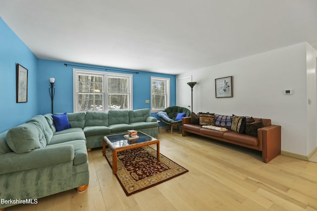 living room with baseboards and light wood-style flooring