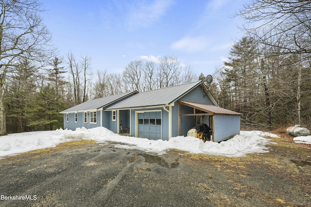 exterior space featuring an attached garage and metal roof