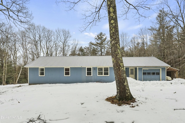 ranch-style house with a garage and metal roof