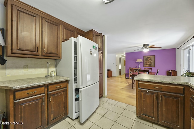 kitchen with light tile patterned floors, light countertops, freestanding refrigerator, and ceiling fan