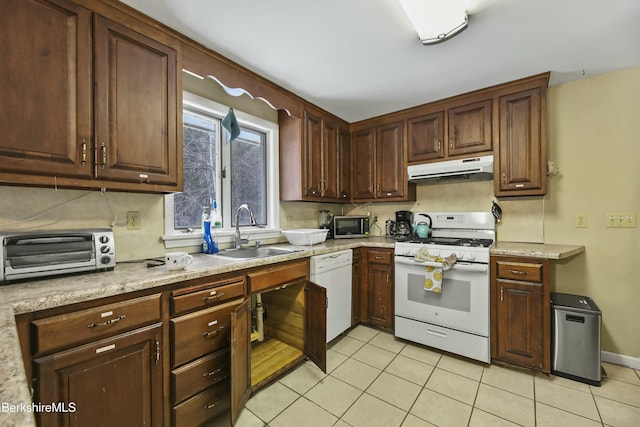 kitchen featuring under cabinet range hood, a sink, white appliances, a toaster, and light tile patterned floors