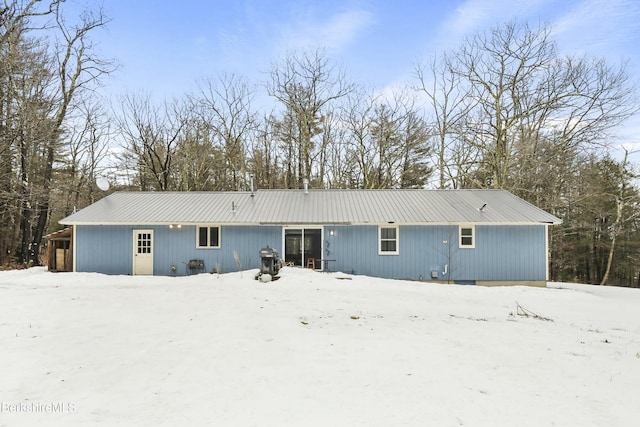 snow covered property with metal roof