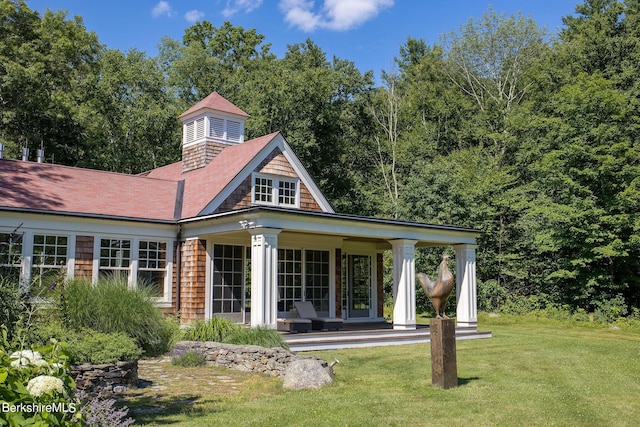 rear view of house with a yard and a porch