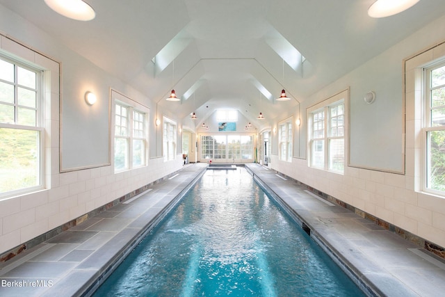 view of swimming pool with a skylight and ceiling fan