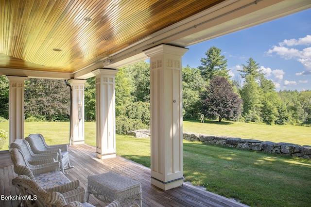 deck featuring covered porch and a lawn