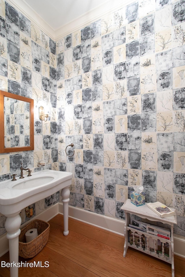 bathroom with crown molding and hardwood / wood-style flooring