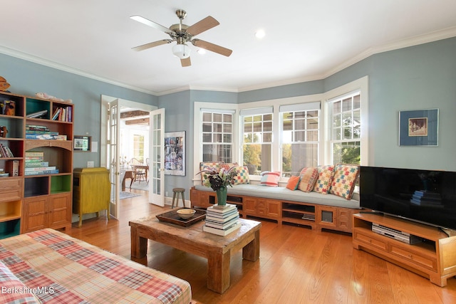 living room with light hardwood / wood-style flooring, ceiling fan, and ornamental molding