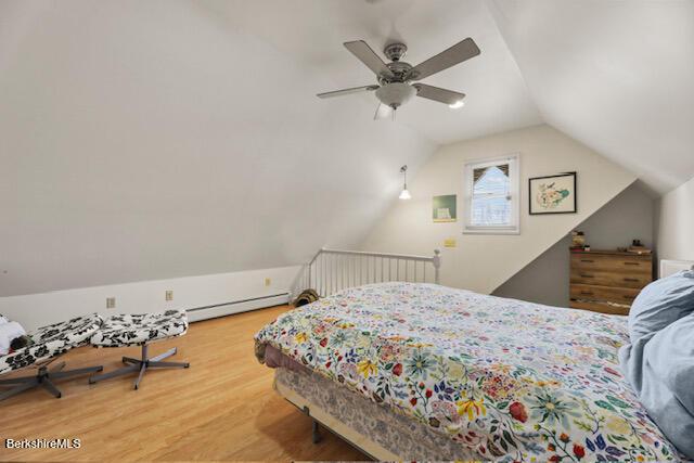 bedroom with baseboard heating, a ceiling fan, lofted ceiling, and wood finished floors