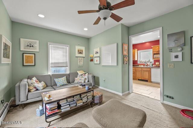 living room with a baseboard heating unit, baseboards, light colored carpet, recessed lighting, and a ceiling fan