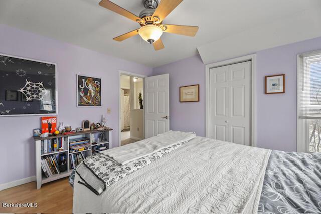 bedroom featuring a closet, baseboards, a ceiling fan, and light wood finished floors