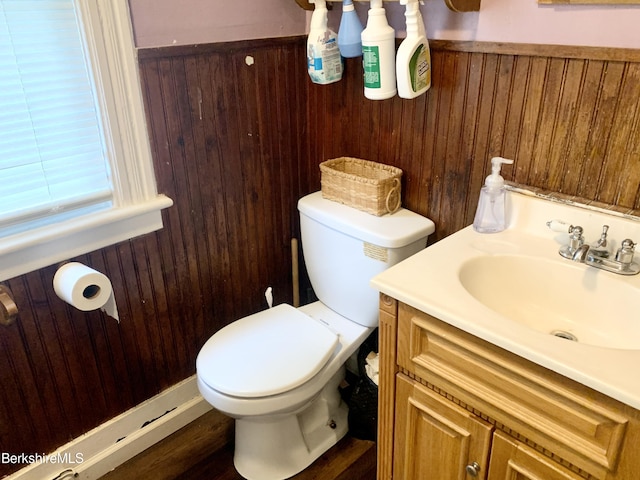 bathroom with vanity, toilet, hardwood / wood-style floors, and wood walls