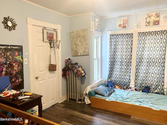 bedroom with ornamental molding and dark hardwood / wood-style floors