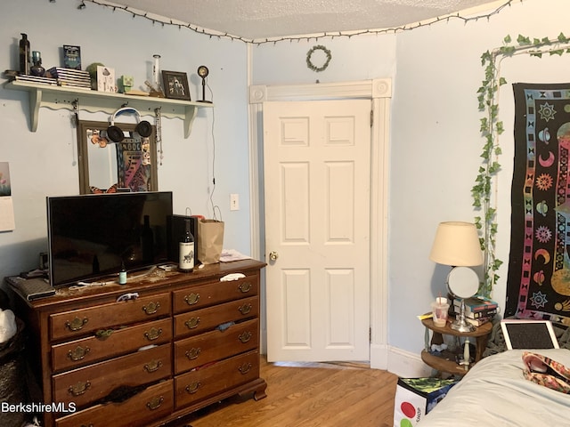 bedroom featuring a textured ceiling and light hardwood / wood-style floors