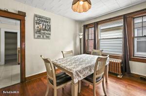 dining room with wood finished floors and radiator