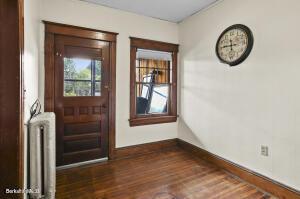 doorway to outside with radiator heating unit and dark wood-style flooring