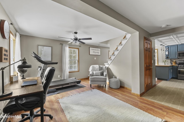 office space featuring light wood-type flooring, ceiling fan, and baseboards