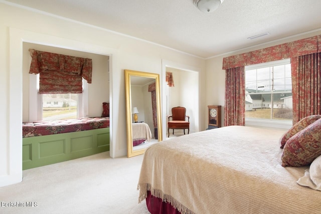 bedroom featuring ornamental molding, carpet flooring, and a textured ceiling