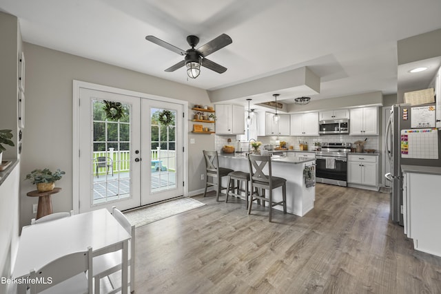 679 Middle Pownal Rd, Pownal, VT 05261 - kitchen featuring stainless steel appliances, french doors, a peninsula, a ceiling fan, and a kitchen bar