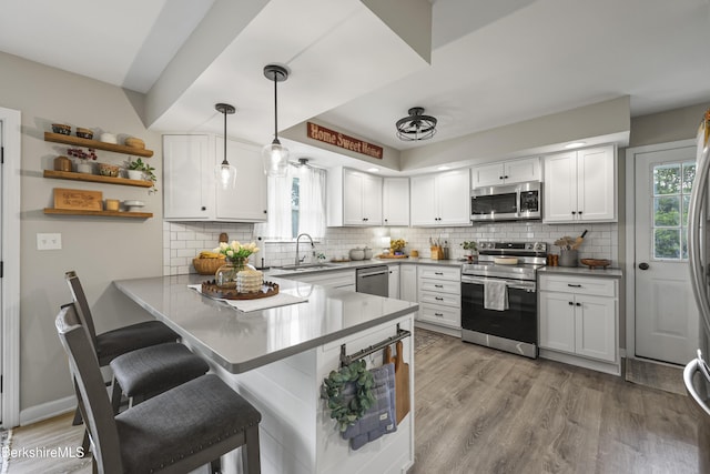 679 Middle Pownal Rd, Pownal, VT 05261 - kitchen featuring stainless steel appliances, a peninsula, a breakfast bar area, and white cabinets