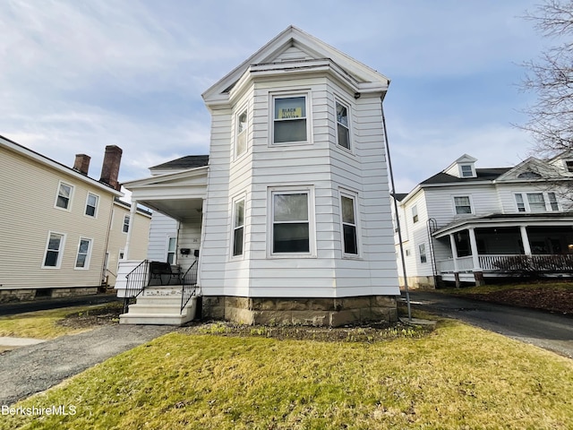 view of front of home with a front yard and covered porch