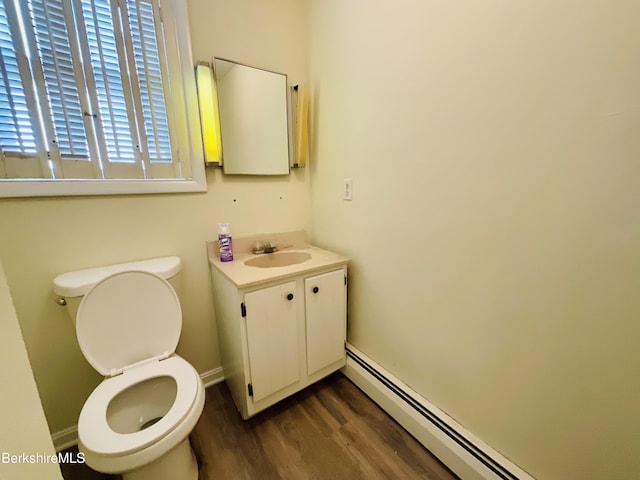 bathroom featuring a baseboard radiator, wood finished floors, vanity, baseboards, and toilet