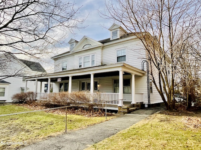 view of front of property with covered porch and a front yard