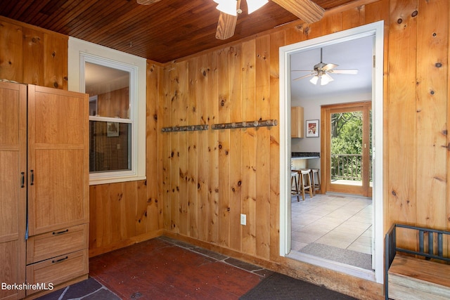 interior space with wood ceiling, ceiling fan, and wood walls