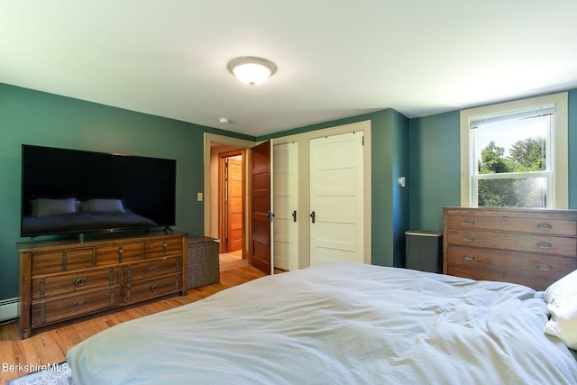 bedroom featuring light hardwood / wood-style floors and baseboard heating