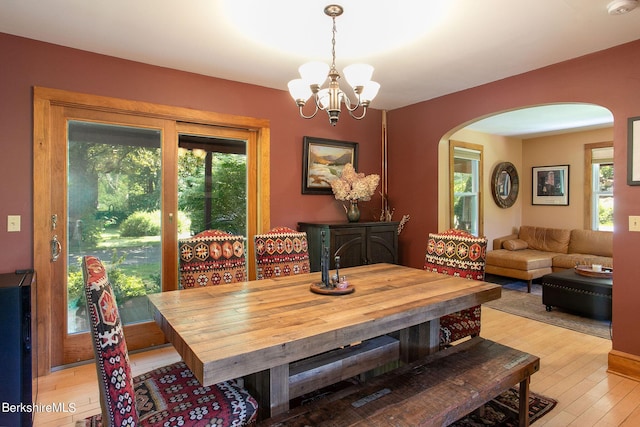 dining space featuring light wood-type flooring and a chandelier