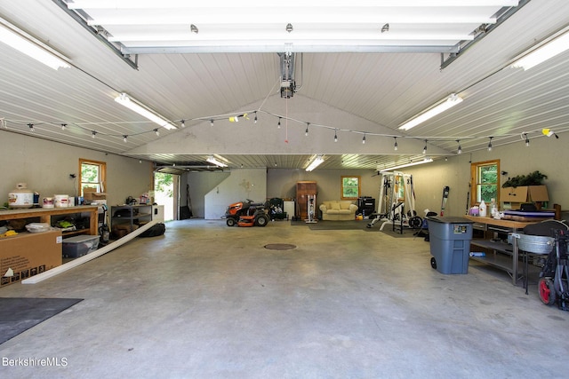 garage with a garage door opener and a workshop area