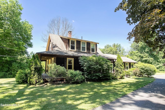 view of front of property featuring covered porch and a front lawn