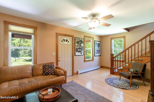 living room with light hardwood / wood-style floors, ceiling fan, and a baseboard heating unit