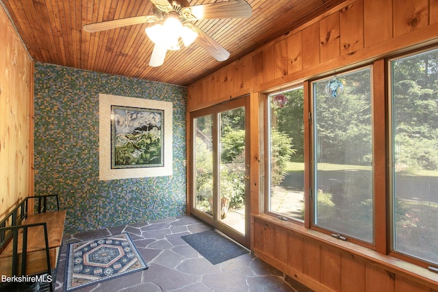 unfurnished sunroom featuring wooden ceiling and ceiling fan