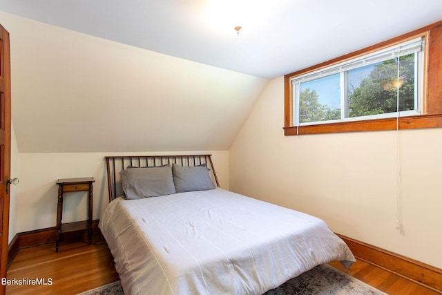 bedroom featuring hardwood / wood-style flooring and vaulted ceiling