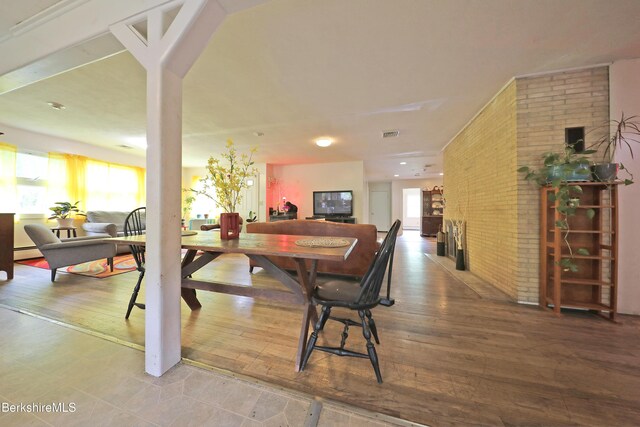 458 Monterey Rd, Great Barrington, MA 01230 - dining room featuring brick wall, hardwood / wood-style flooring, and a baseboard heating unit