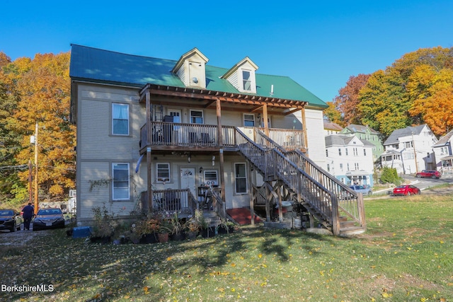 rear view of house featuring a yard