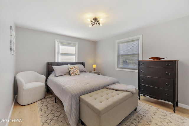 bedroom featuring baseboards and light wood finished floors