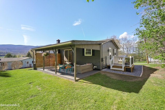 back of house with a yard, a deck, and a patio area
