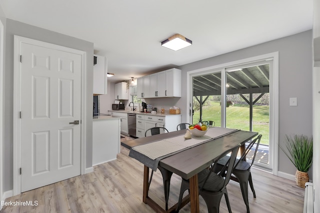 dining area featuring baseboards and light wood finished floors
