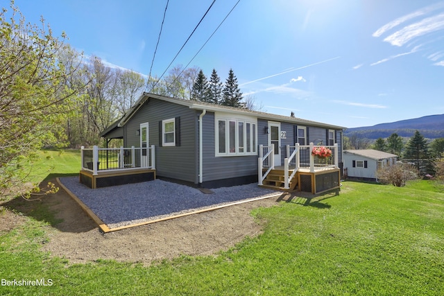 exterior space with a yard and a deck with mountain view