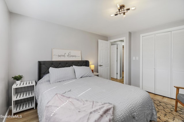 bedroom featuring a closet, baseboards, and light wood-type flooring