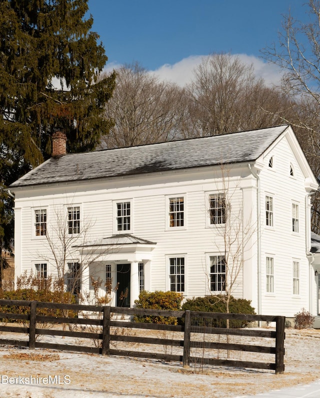 view of front of property with a fenced front yard and a chimney